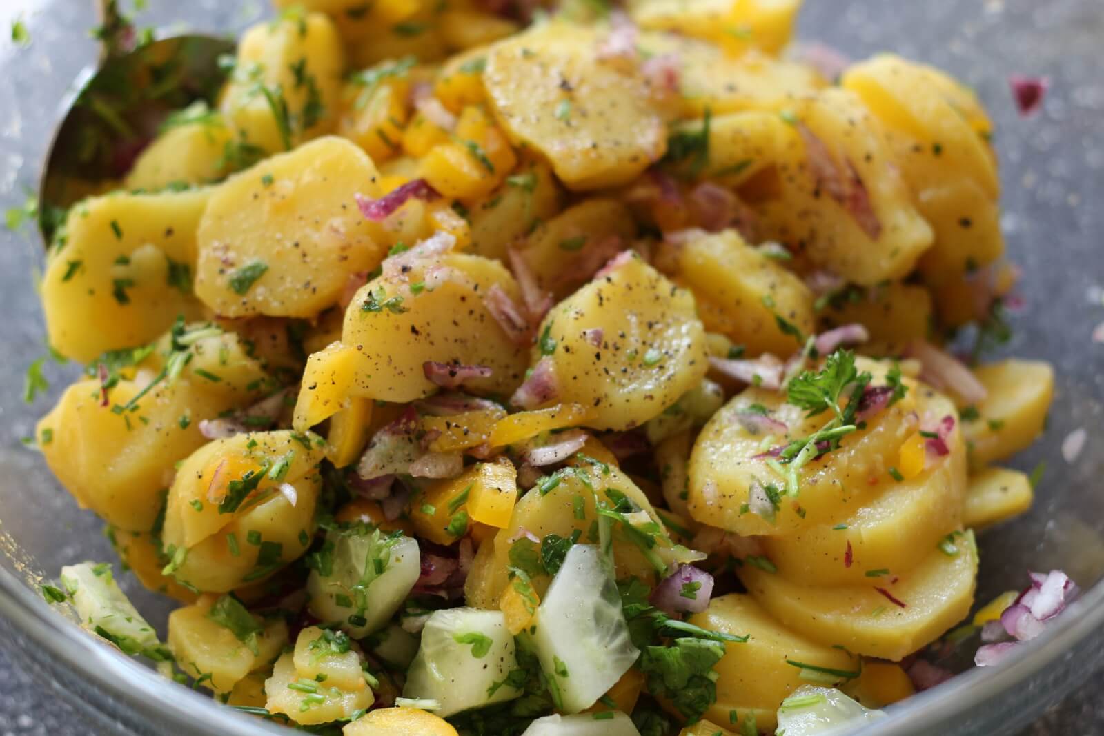 Kartoffelsalat dient als Beilage für traditionelles Essen, da nach Zuhause schmeckt.