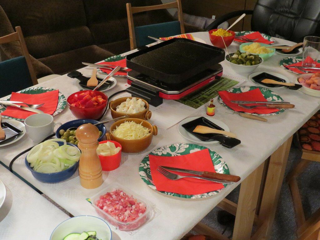 Bei Raclette Essen steht der Tisch mit Zutaten voll.