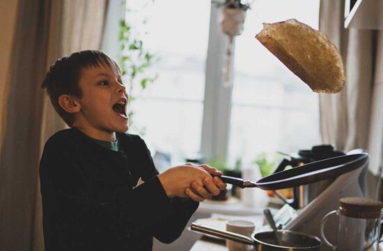 Pfannkuchen zubereiten ist kinderleicht, wie uns der Junge beim Hochwerfen zeigt