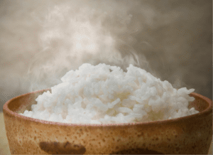 Gekochter Reis für Essen wie Zuhause und Hähnchenschenkel in Mais-Reis