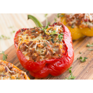 Gefüllte Paprika mit Hackfleisch als Low carb Gericht oder leckeres Abendessen angerichtet auf Holzbrett
